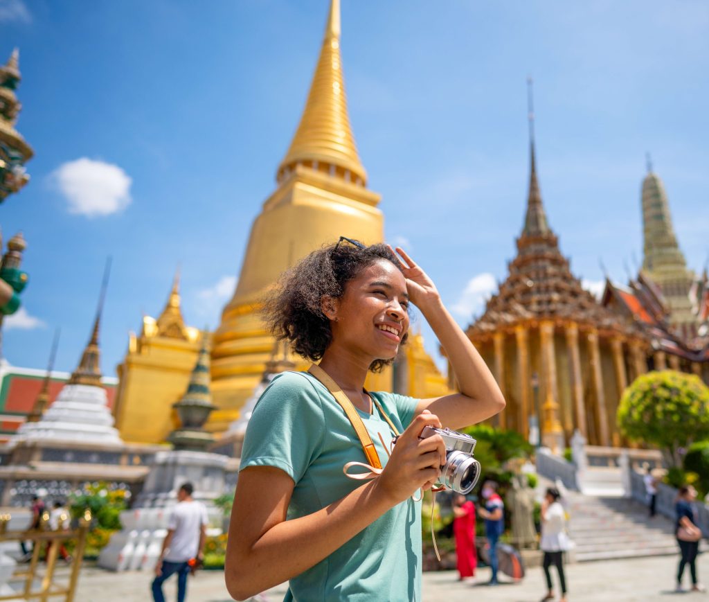 Young woman traveler with backpack traveling into beautiful pagoda in Wat Pra Kaew Witthaya Prasongsin GettyImages-1333211288 rfc